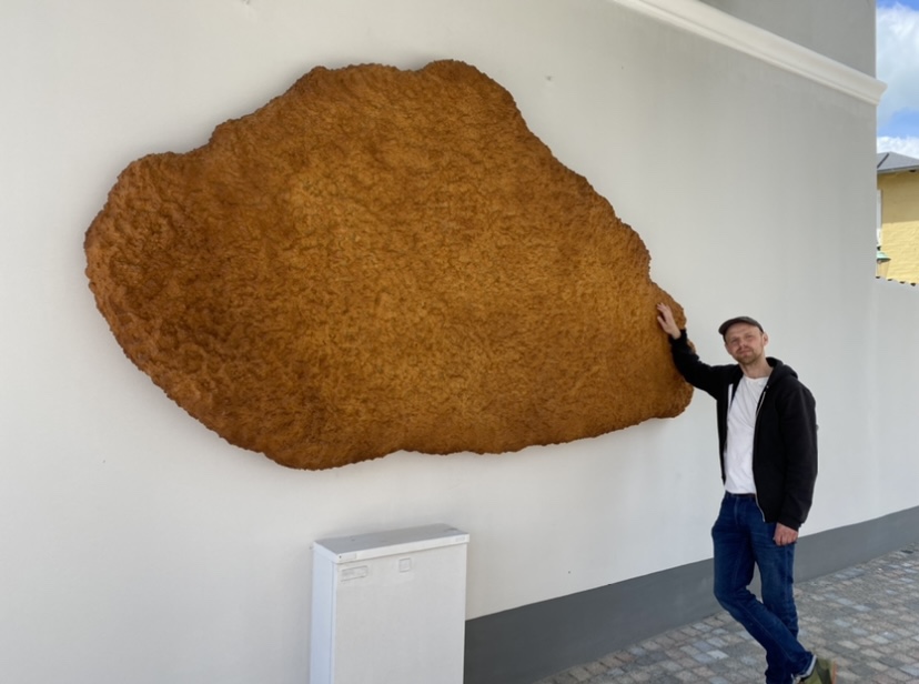 Det var en glad kunstner Torben Ribe, der i dag kunne se sit værk i form af en 108 kilo og adskillige meter stor fiskefilèt hænge på sidegavlen ved det hus hvor Aabenraa Antik ligger. Foto: Erik Egvad Petersen - www.sydnyt.dk
